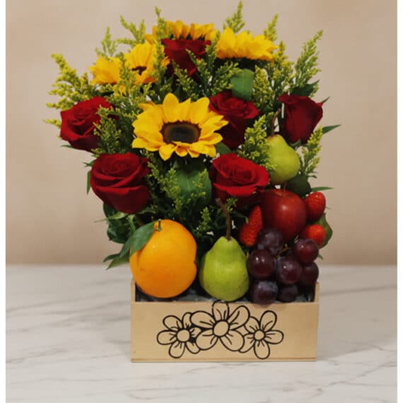 Arreglo Floral Adriano: Rosas Rojas, Girasoles y Frutas Frescas Arreglo floral Adriano con rosas rojas, girasoles vibrantes, naranjas, peras, uvas y fresas en una caja de madera decorada, i
