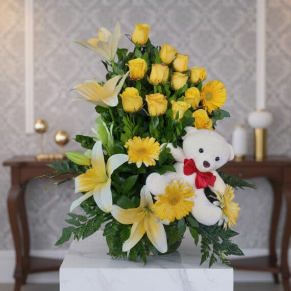 Arreglo Floral Exótico Amaretto con Rosas Amarillas y Lirios Arreglo floral exótico Amaretto con rosas amarillas, lirios blancos y gerberas, acompañado de un oso de peluche blanco con la