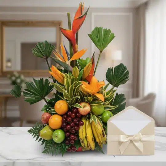 Arreglo floral exótico con frutas frescas como naranjas, manzanas, uvas y plátanos, acompañado de flores de ave del paraíso y