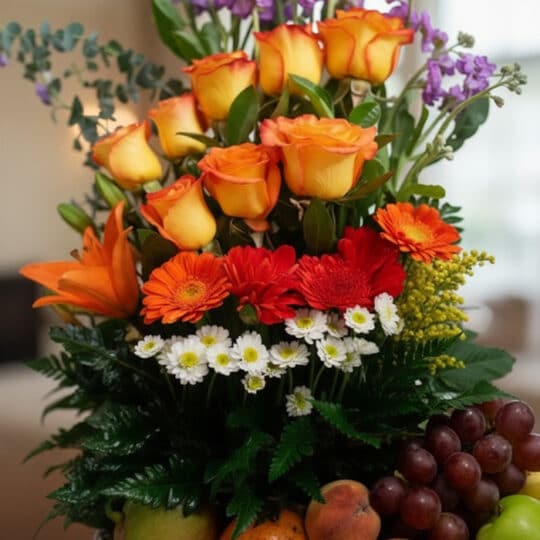 Primer plano extremo del Arreglo Floral con Frutas Hadar, mostrando rosas naranjas, gerberas rojas y margaritas blancas con g