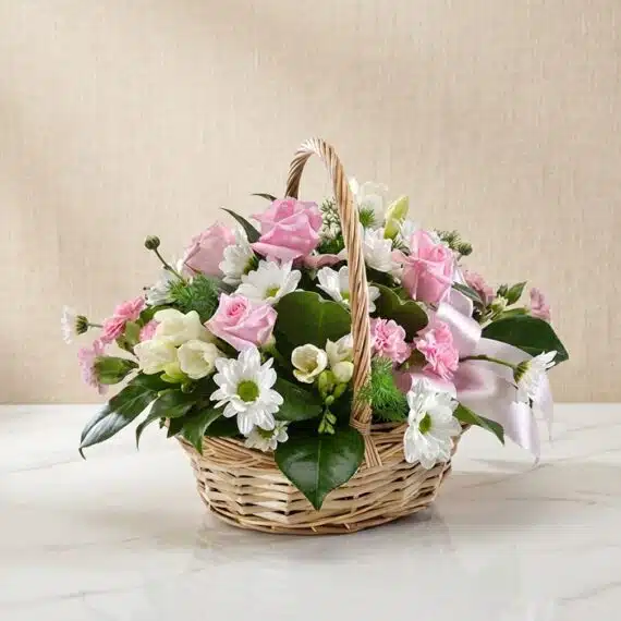 Arreglo Floral RACHELE: Cesta Delicada con Rosas Rosadas y Flores Frescas Cesta de mimbre con 12 rosas rosadas, margaritas blancas, freesias y claveles, ideal para regalar en ocasiones especiales.