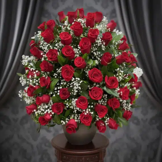 Arreglo Floral Rosas por Montón: Belleza Clásica y Elegancia Impresionante arreglo floral de rosas rojas frescas y gypsophila en un jarrón gris sobre una mesa de madera, con un fondo ele