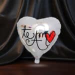 Globo metalizado en forma de corazón con la frase 'Te Amo' y un corazón rojo, ideal para expresar amor en cualquier ocasión e